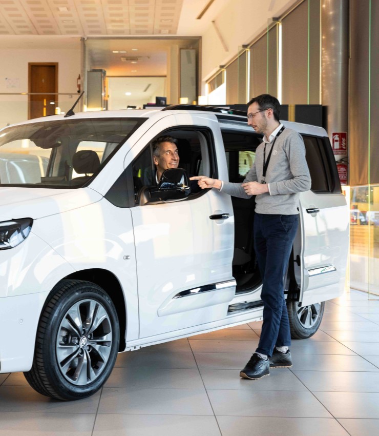 Un comercial de Compostela Móvil enseña un Toyota Proace City blanco a un cliente en el concesionario