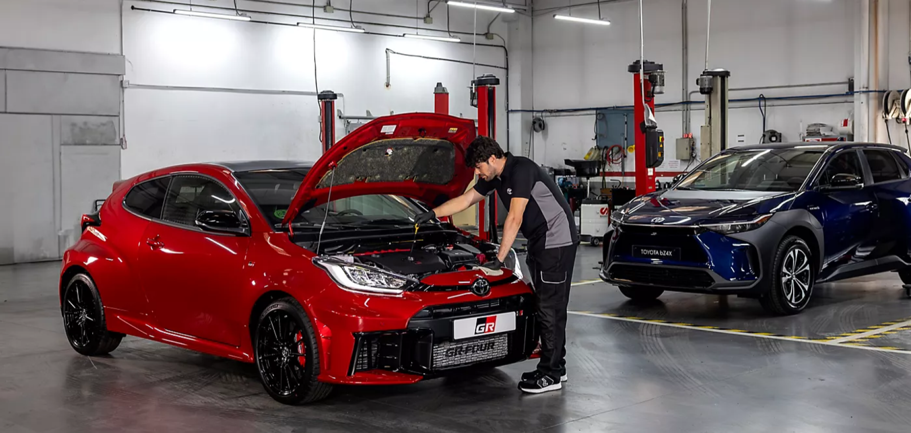 Mecánico trabajando en un Toyota GR Yaris rojo con el capó abierto en el taller de Compostela Móvil