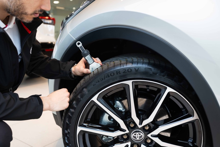 Técnico midiendo el dibujo del neumático de un Toyota durante una revisión