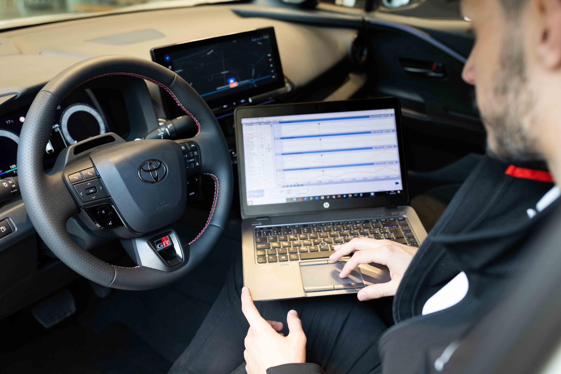 Técnico de Compostela Móvil consultando un diagnóstico en el ordenador dentro de un Toyota